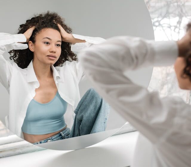 beautiful woman looking at herself in mirror